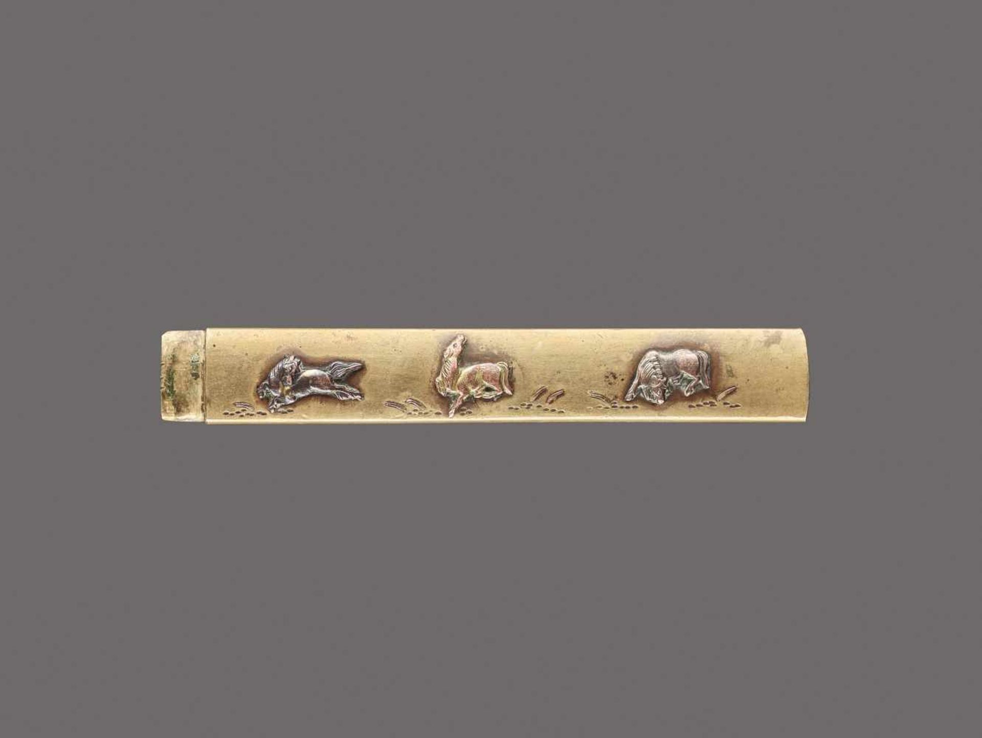 A GILT COPPER KOZUKA HANDLE DEPICTING THREE HORSES Unsigned, kozuka handle, gilt copper, shakudo,