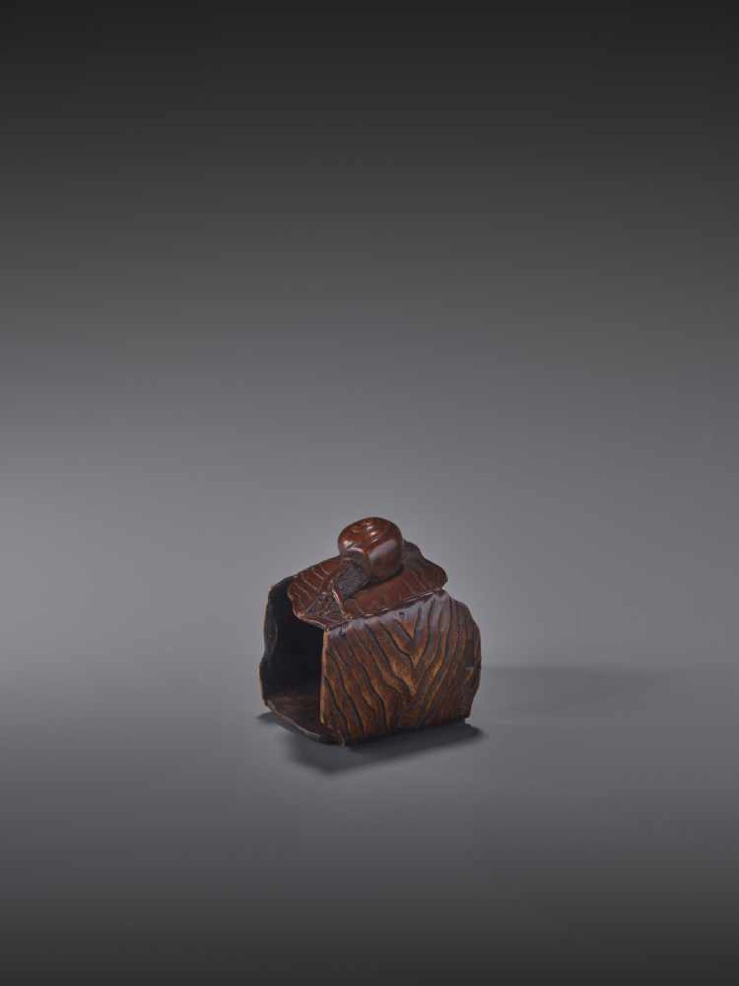 A FINE WOOD NETSUKE OF A SNAIL ON A BUCKET BY MASANAO By Masanao, wood netsukeJapan, Ise-Yamada,