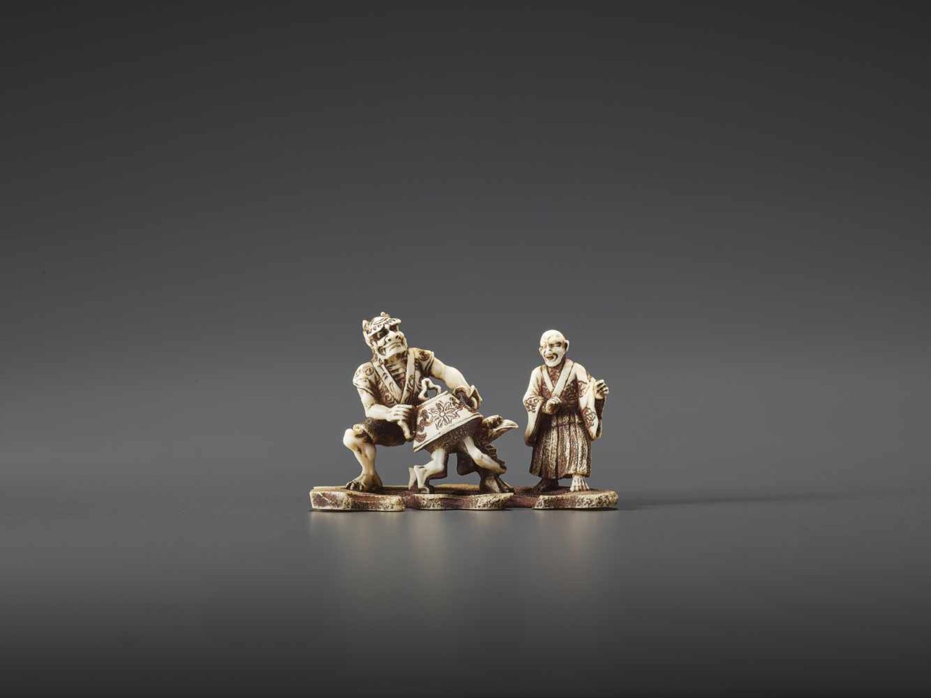 A MINUTELY CARVED IVORY NETSUKE OF ONI, KAPPA AND MONK SIGNED TENMIN Signed Tenmin, ivory