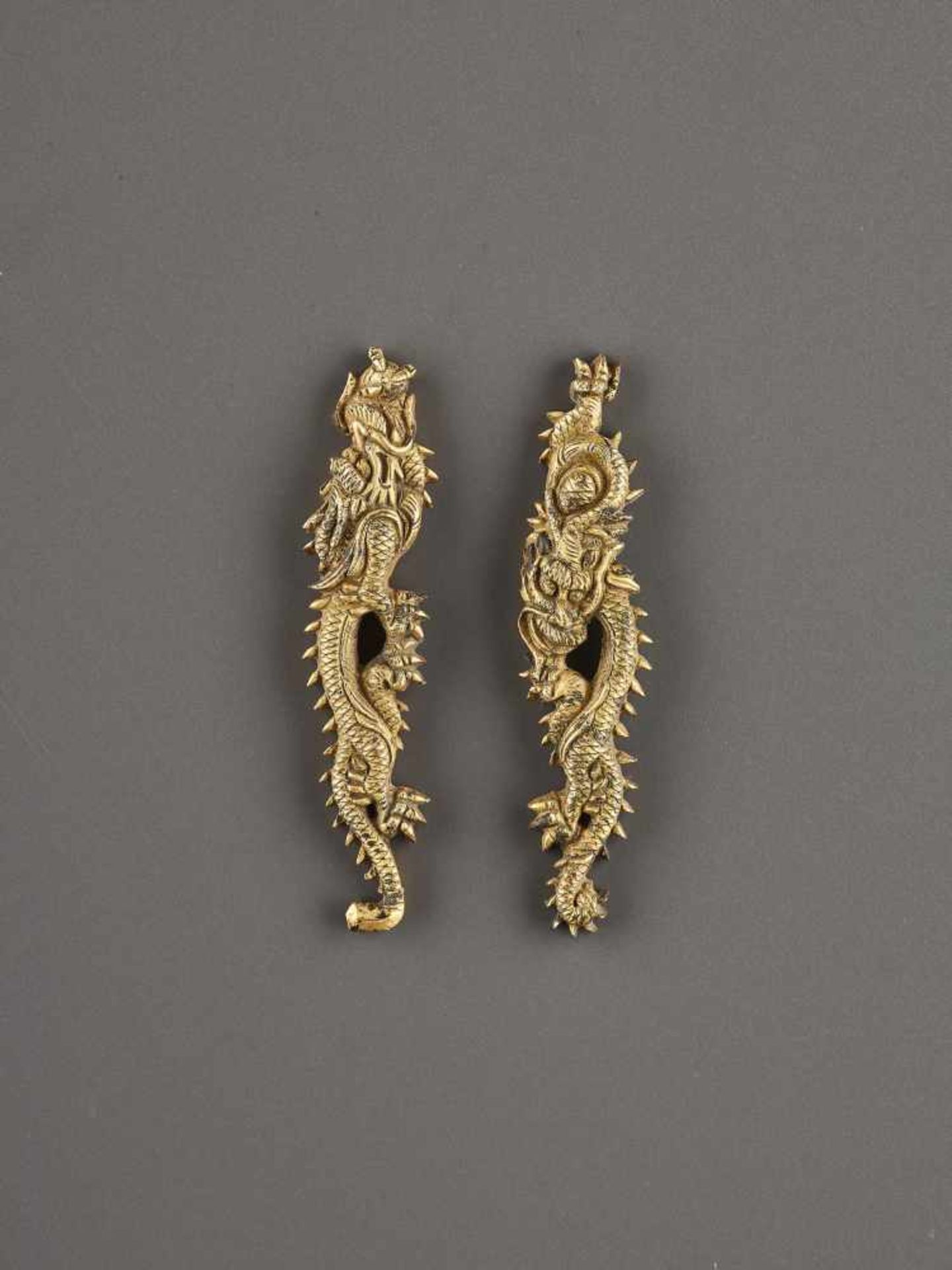 A PAIR OF GILT SHAKUDO DRAGON MENUKI Unsigned, gilt shakudoJapan, Edo period (1615-1868)Each