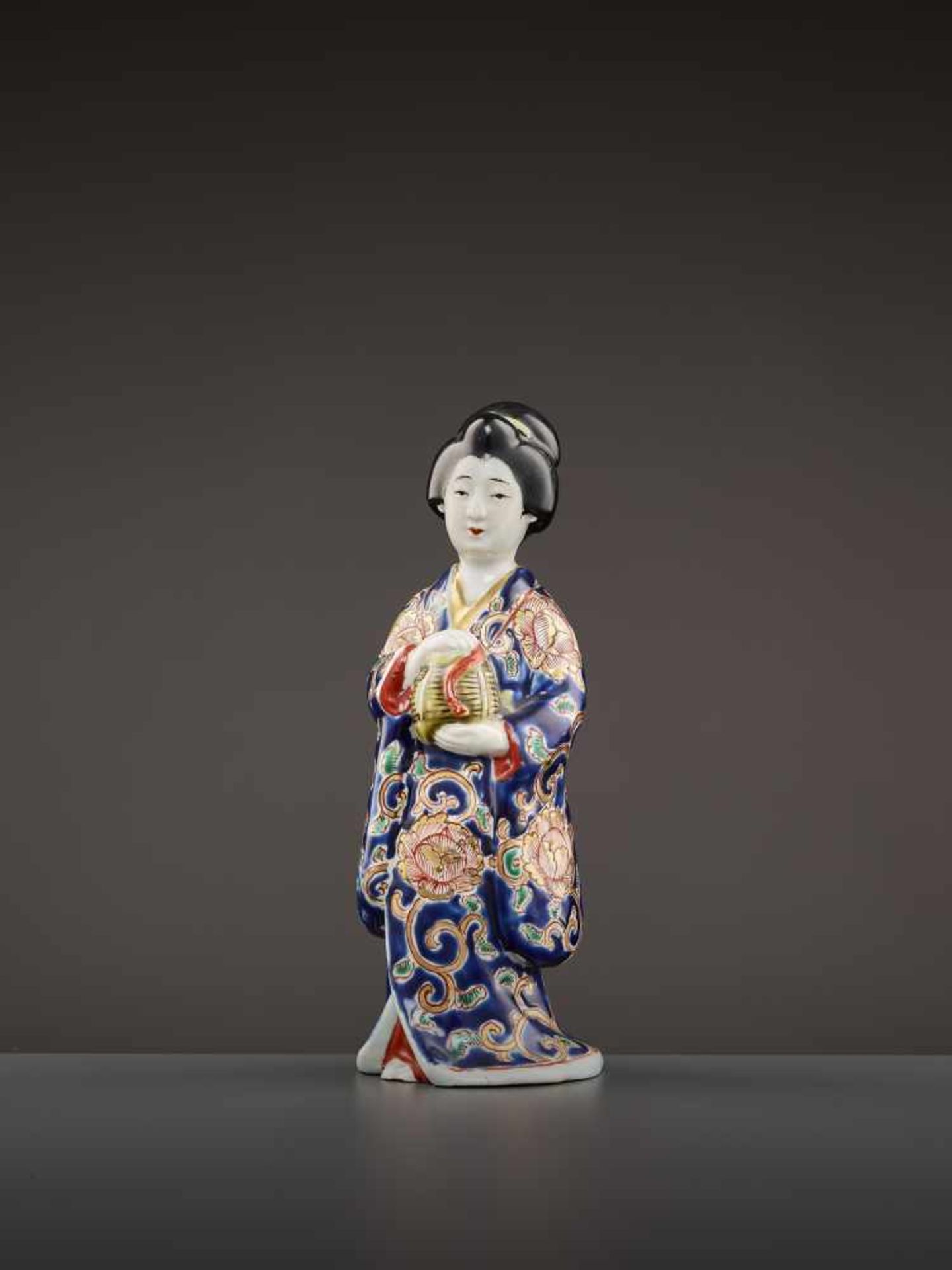 A PORCELAIN OKIMONO OF A BIJIN   Japan, Meiji period (1868-1912). Finely modeled statue with