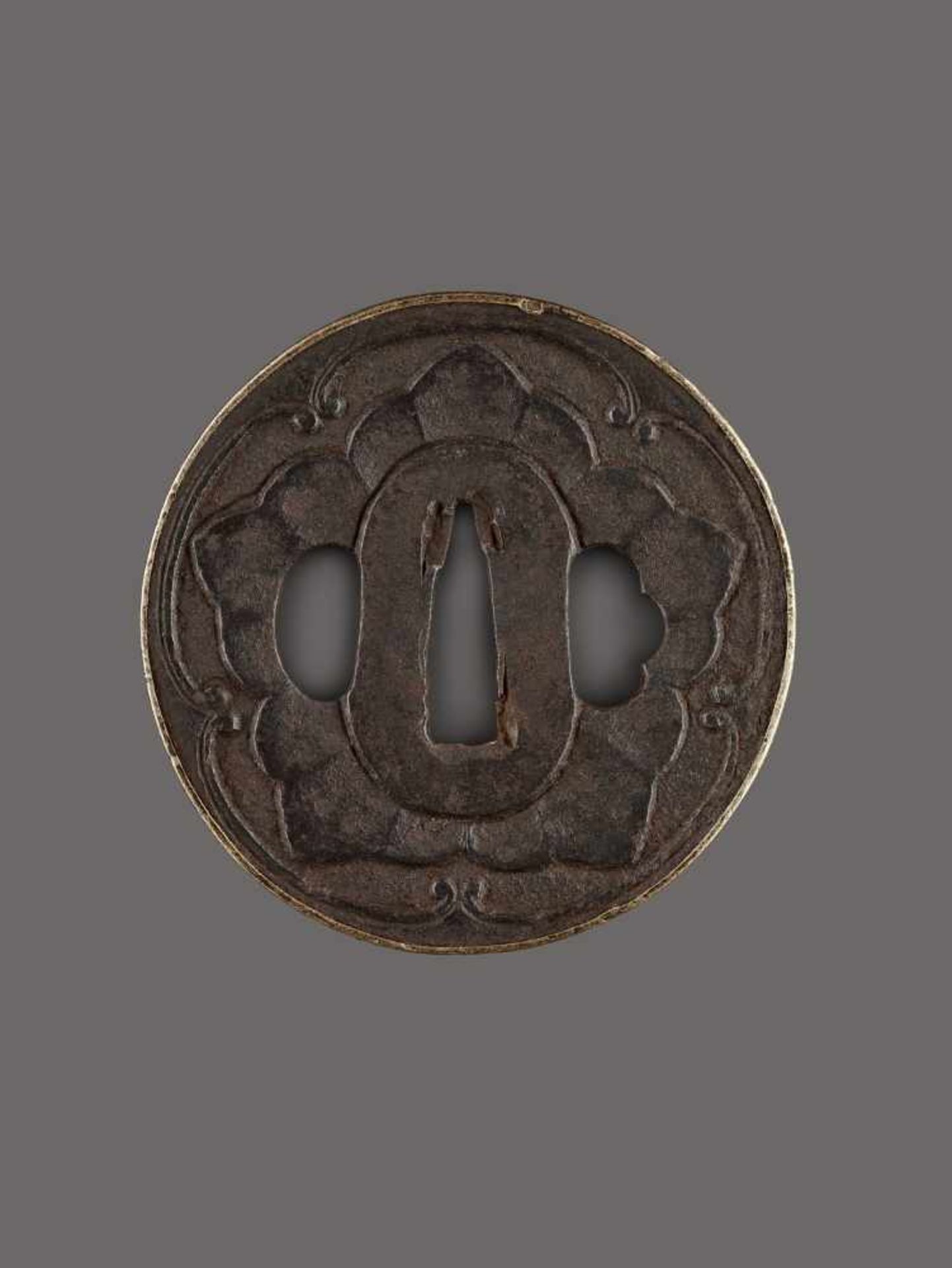 AN IRON TSUBA WITH MON CREST IronJapan, Edo period (1615-1868)Of Maru Gata shape with a raised and