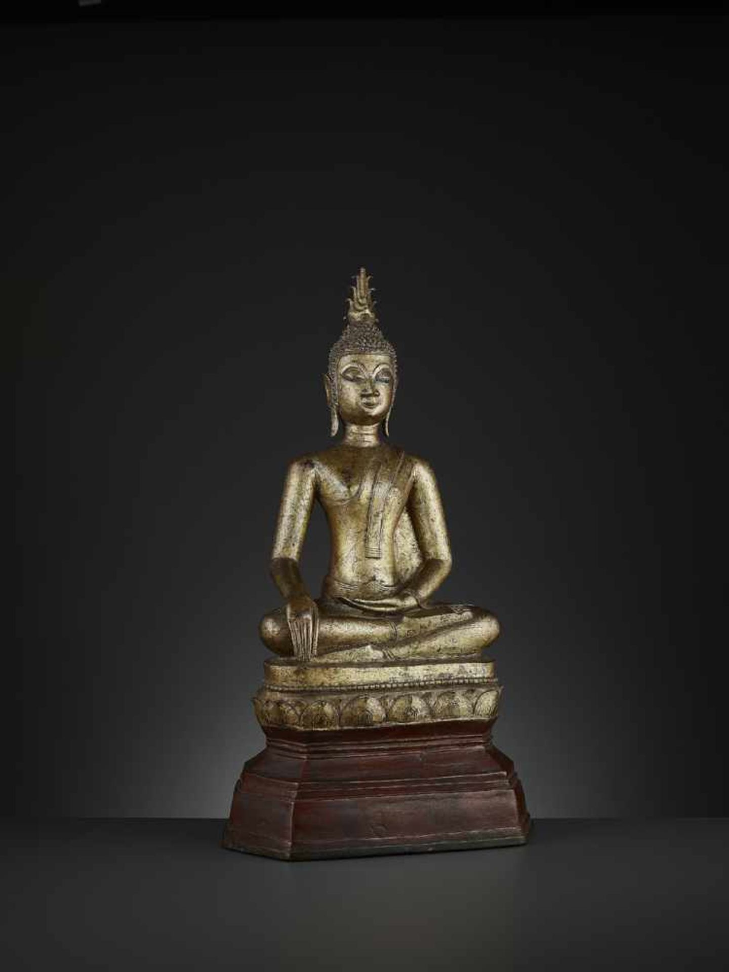 A GILT BRONZE STATUE OF BUDDHA SHAKYAMUNI Laos, 17th – 18th century. Massively cast seated in