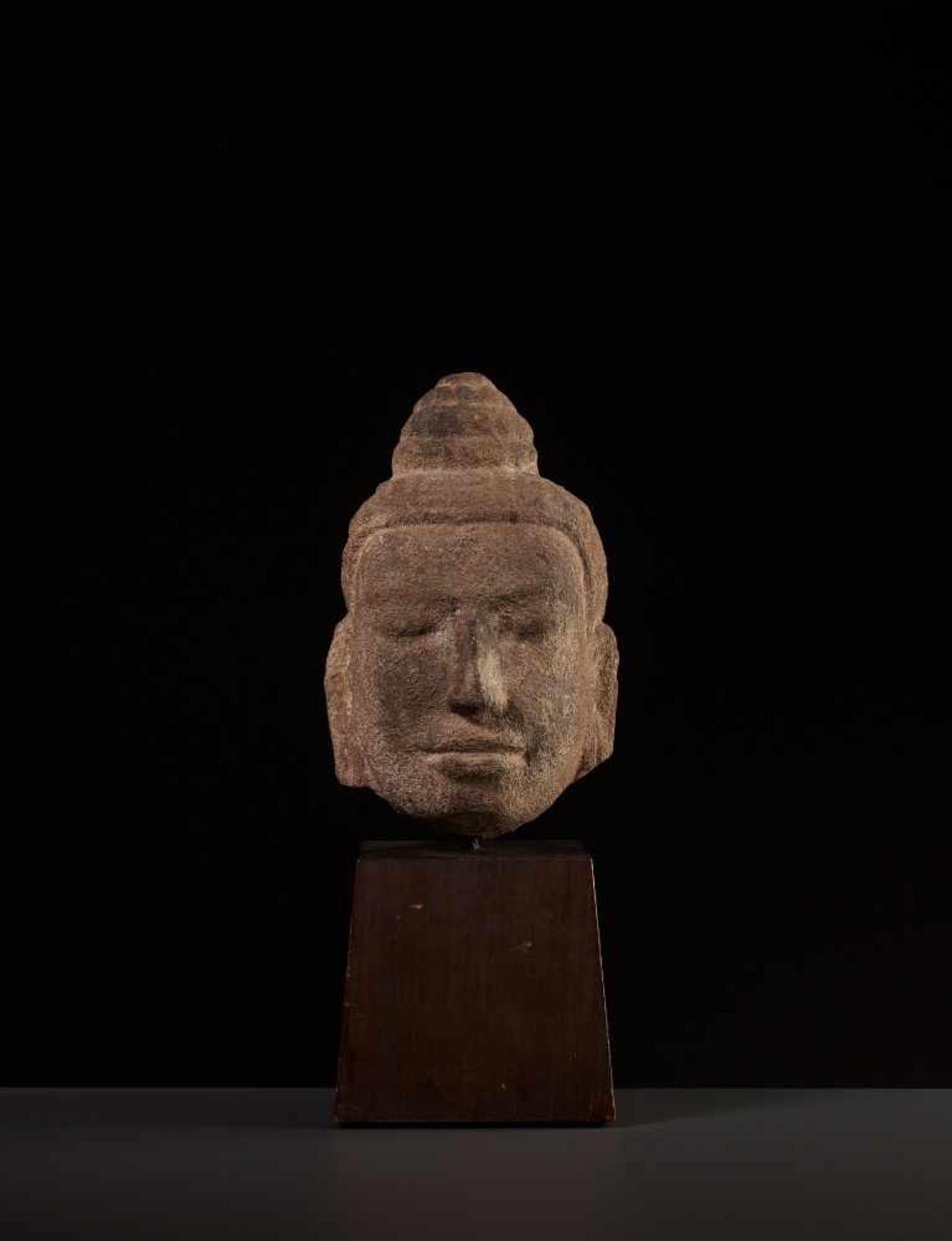 A FINE SANDSTONE HEAD OF BUDDHA, KHMER Cambodia, 11th-12th century. The face with a benevolent