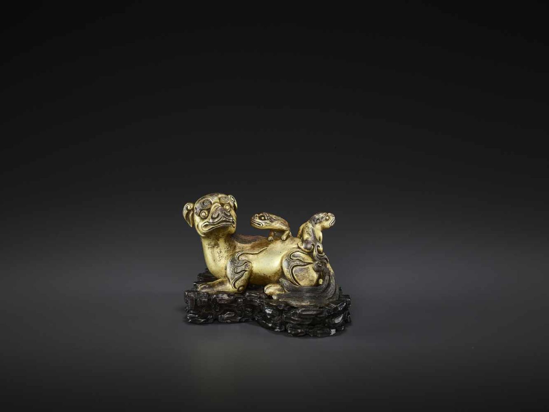 A FINE BUDDHIST LION GILT-BRONZE SCROLL WEIGHT, KANGXI China, 1662-1722. The mythical beast finely