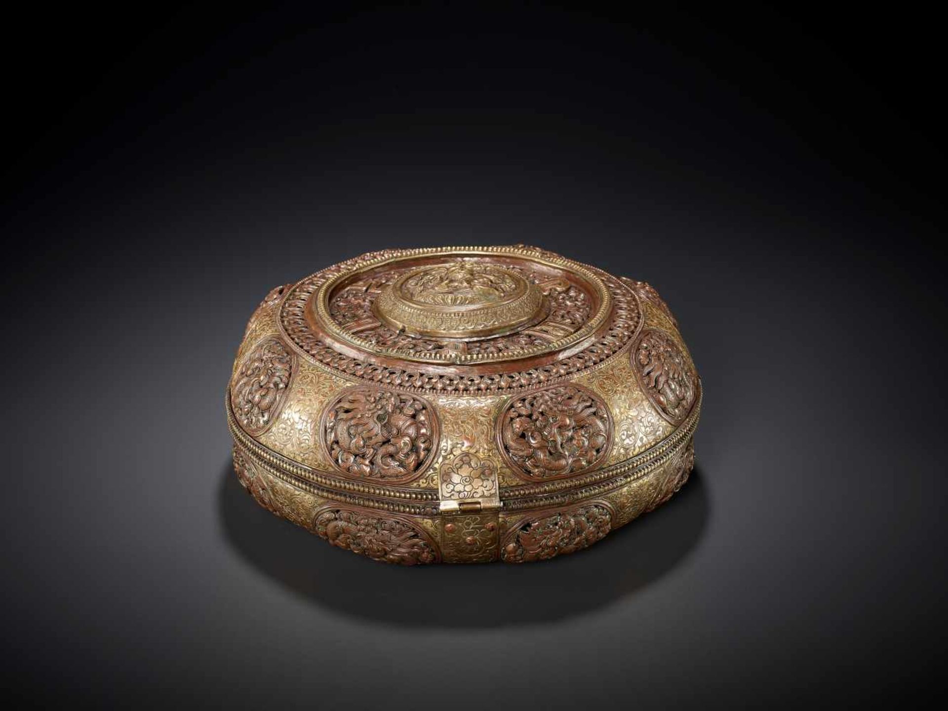 A GILT COPPER REPOUSSÉ RICE CONTAINER Tibet, 17th – 18th century. Finely engraved, embossed and