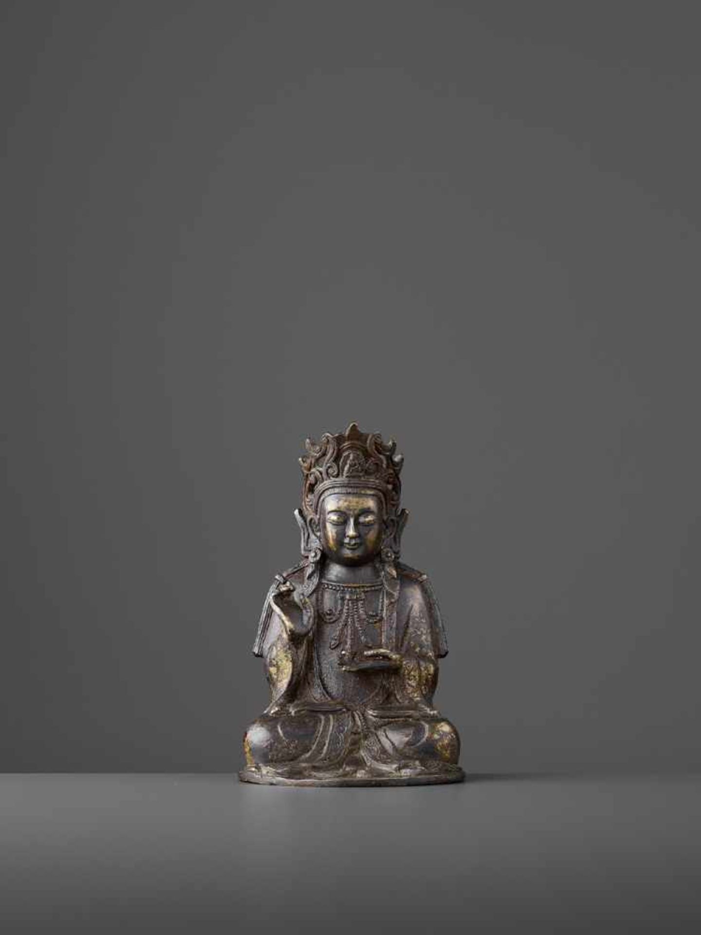 A FINELY CAST BRONZE GUANYIN, MING China, 1368-1644. The figure seated in padmasana, the right
