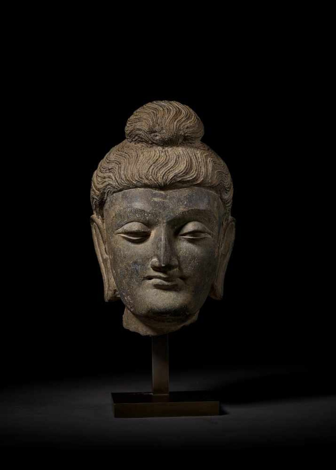 A LARGE HEAD OF BUDDHA, GANDHARA Ancient region of Gandhara, 3rd-4th century. Successfully evoking