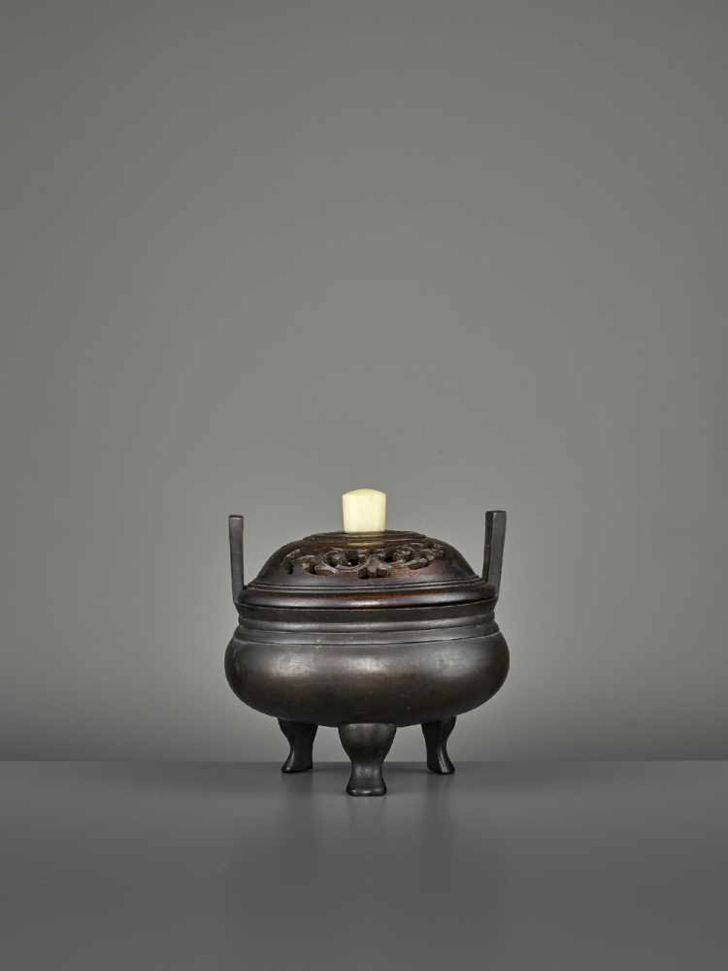 A BRONZE TRIPOD CENSER, MING China, 17th century. The incense burner standing on three feet, with