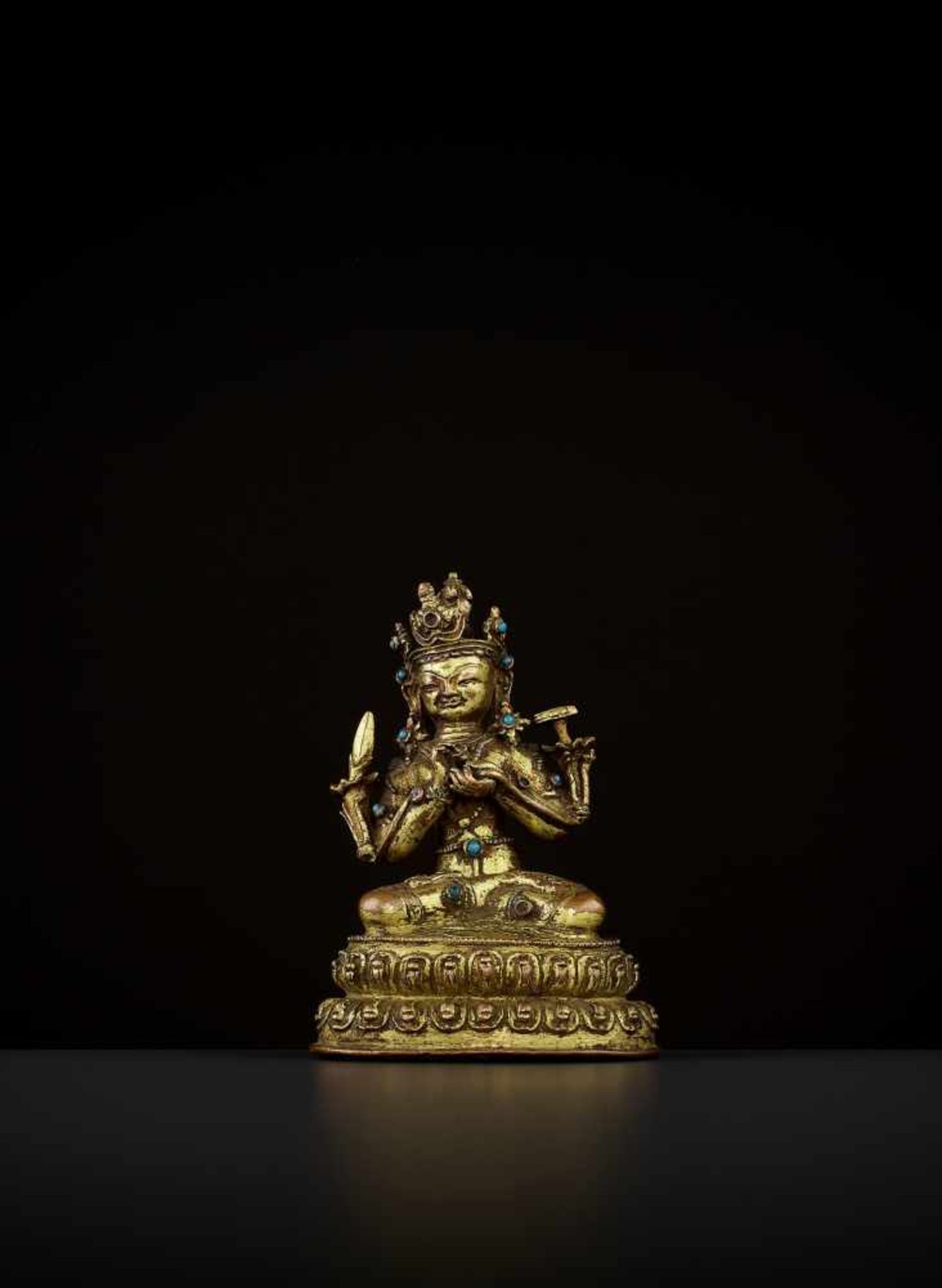 A GILT-BRONZE OF MANJUSHRI Tibet, 14th-15th century. The bodhisattva is seated in vajrasana on a