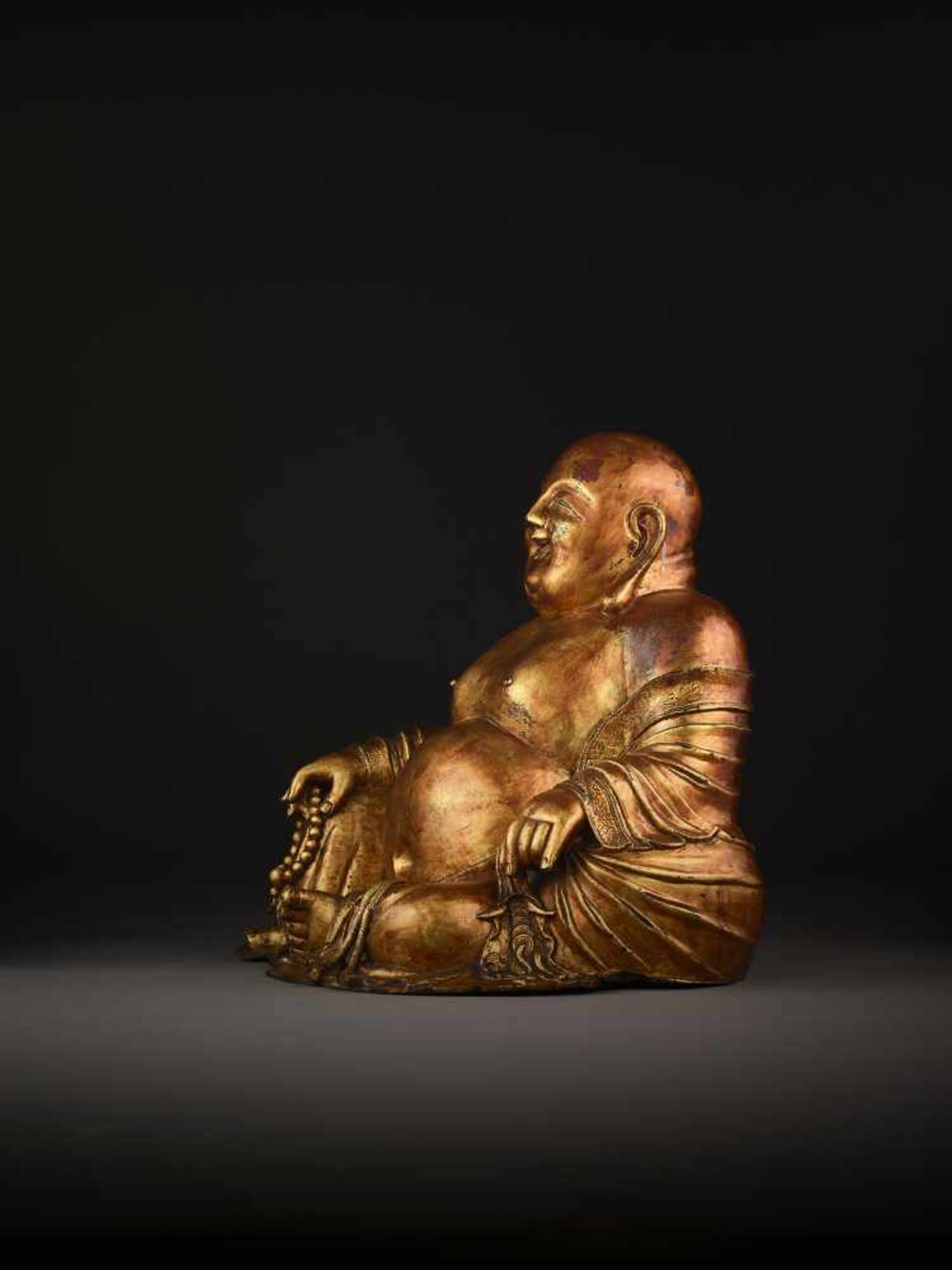 A LARGE GILT BRONZE FIGURE OF BUDAI China, 1368-1644. The smiling, corpulent figure is shown - Image 10 of 14