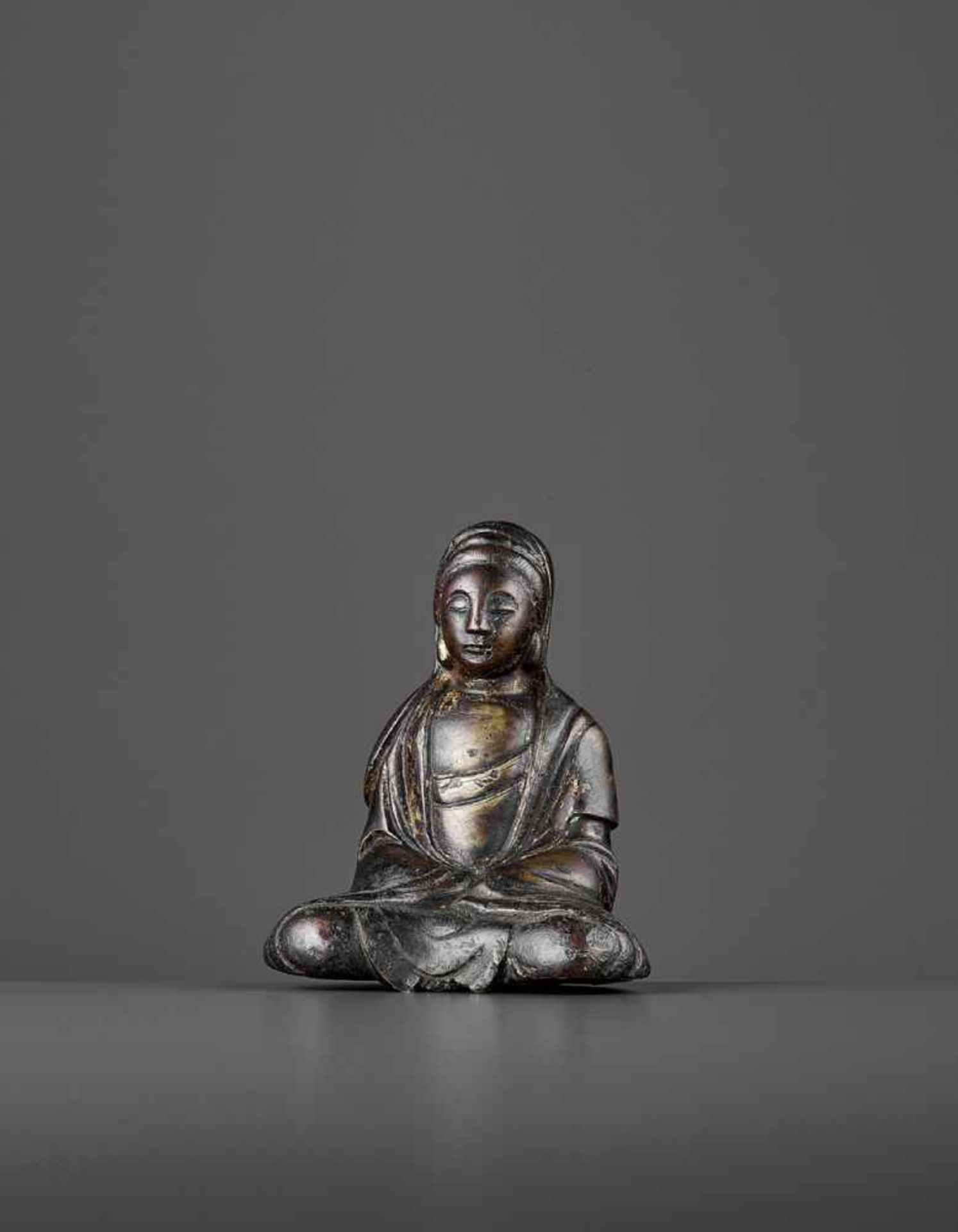 A SMALL BRONZE OF GUANYIN, LIAO DYNASTY China, 916-1125. The heavily cast figure seated in