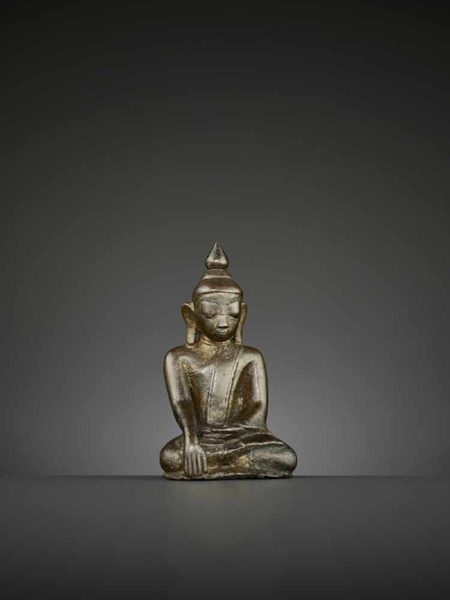 A BUDDHA BRONZE, BURMA, 14TH CENTURY The superbly cast statue depicting Shakyamuni seated in