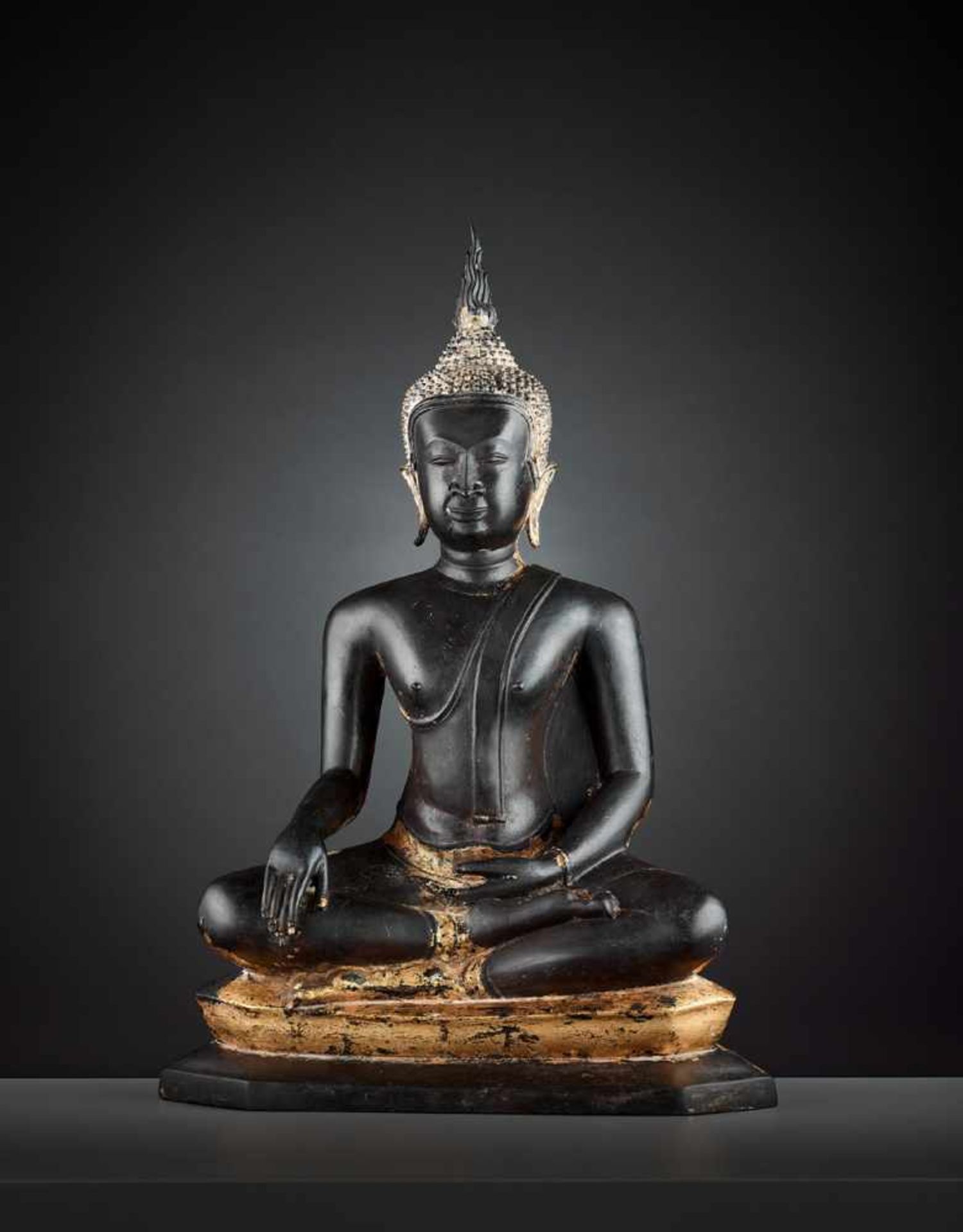 A BUDDHA SHAKYAMUNI LACQUER-GILT BRONZE Laos, 19th – early 20th century. Buddha is cast seated in