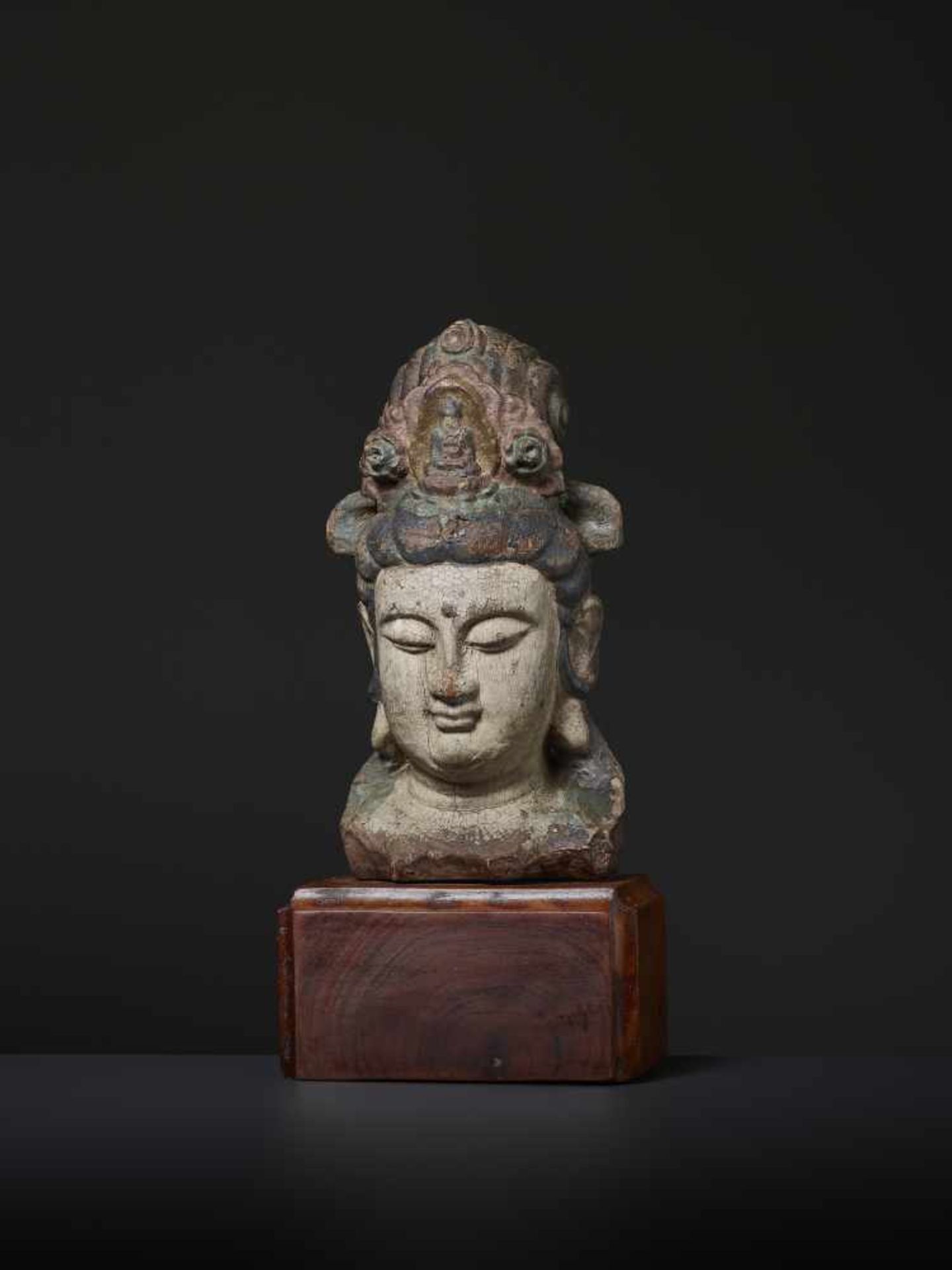 A LACQUERED WOOD HEAD OF GUANYIN, MING China, 1368-1644. The bodhisattva is carved with a high