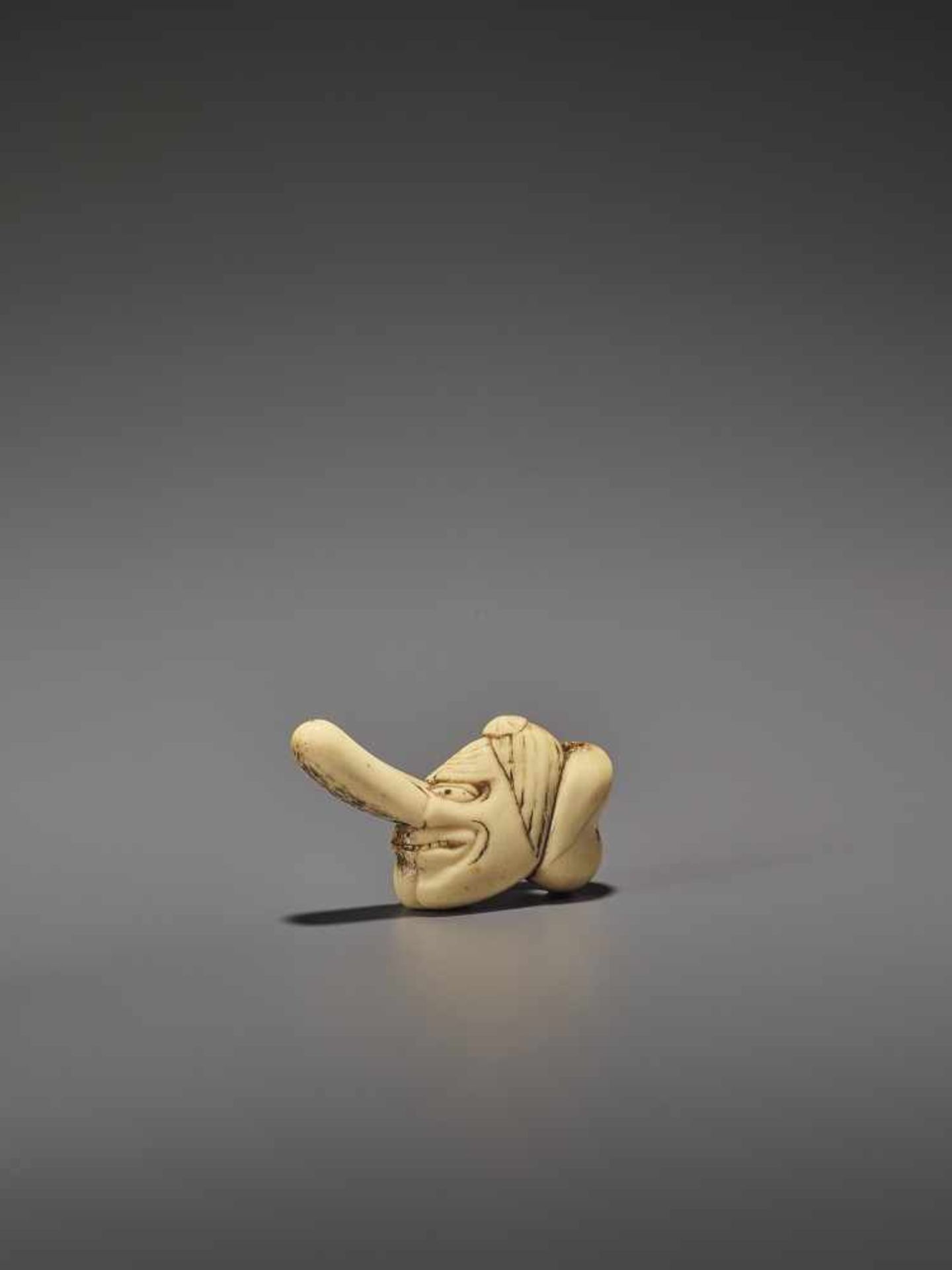 A RARE STAG ANTLER SHUNGA NETSUKE OF OKAME AND TENGU MASKS UnsignedJapan, 19th century, Edo