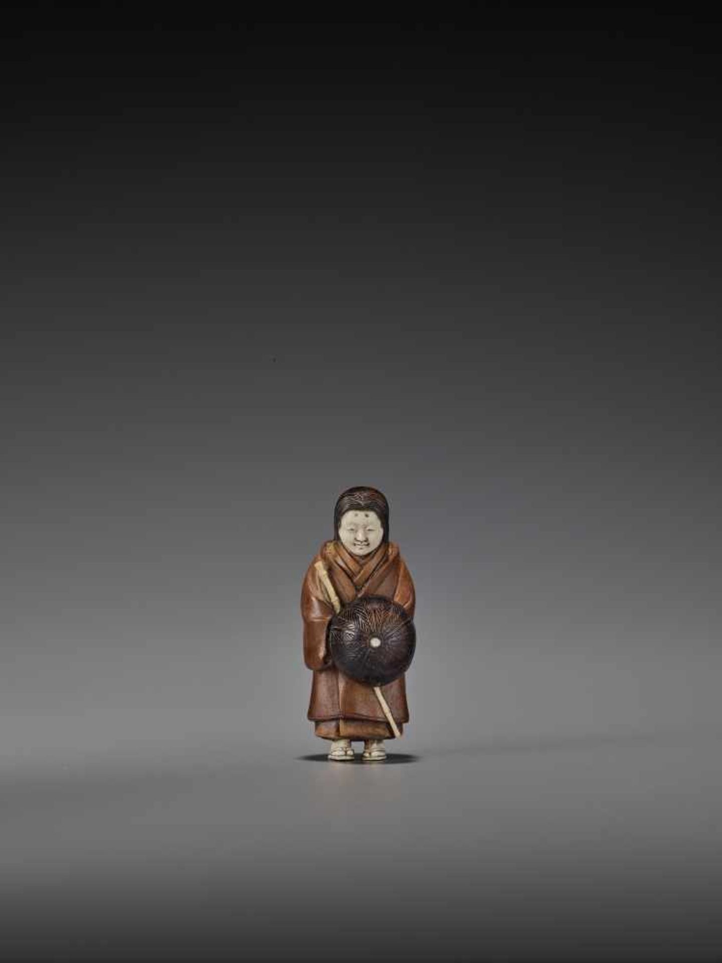 RAKUMIN: A RARE WOOD AND IVORY NETSUKE OF A VISITING COURTESAN By Ho Rakumin, signed RakuminJapan,