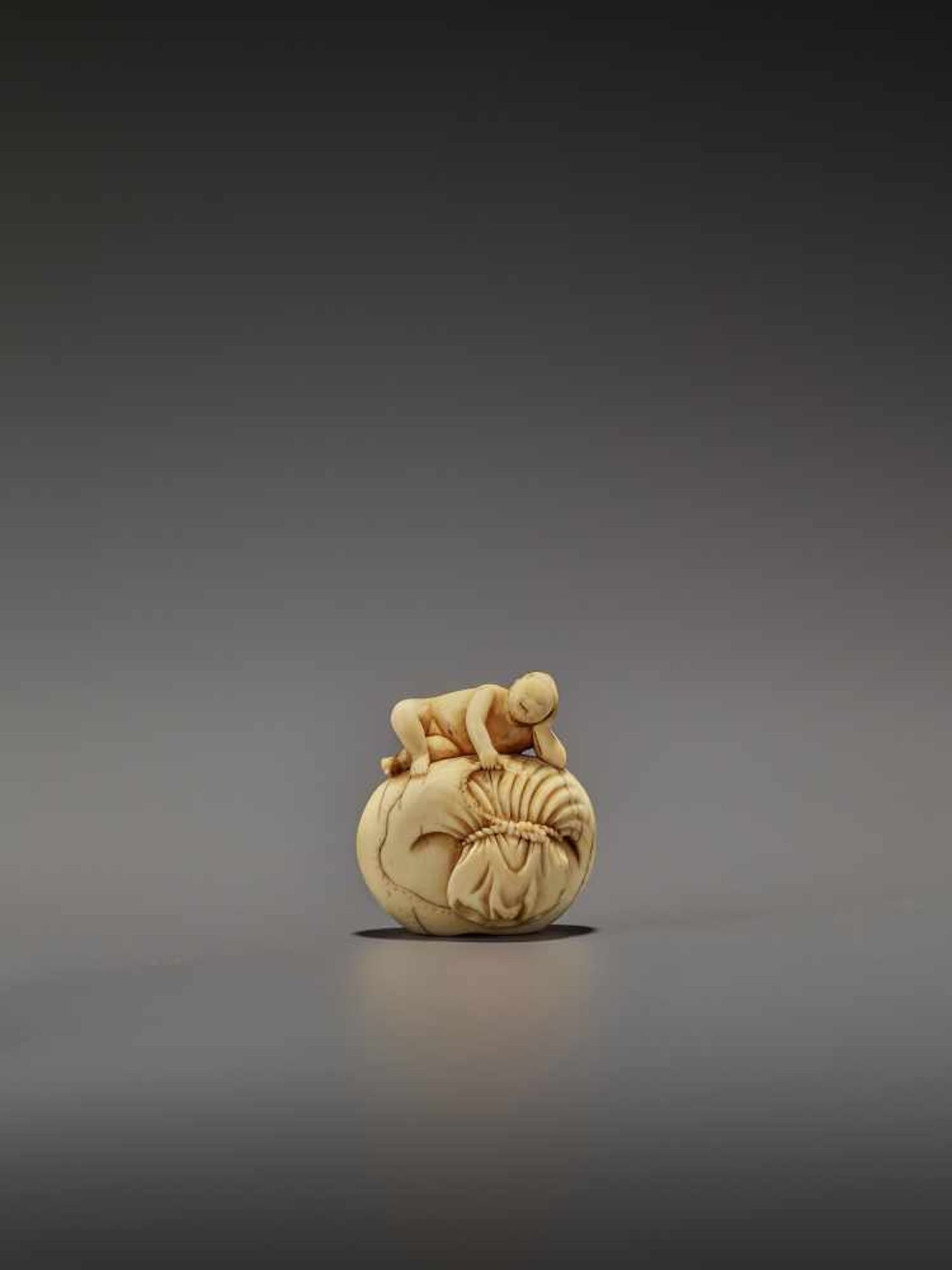 AN EARLY IVORY NETSUKE OF A NAKED MAN SLEEPING ON A BAG UnsignedJapan, mid-18th century, Edo