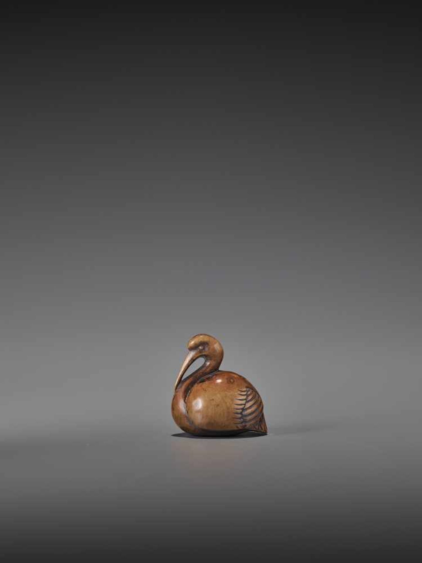 A RARE AND ELEGANT WOOD NETSUKE OF A CRANE UnsignedJapan, 18th century, Edo period (1615-1868)A wood