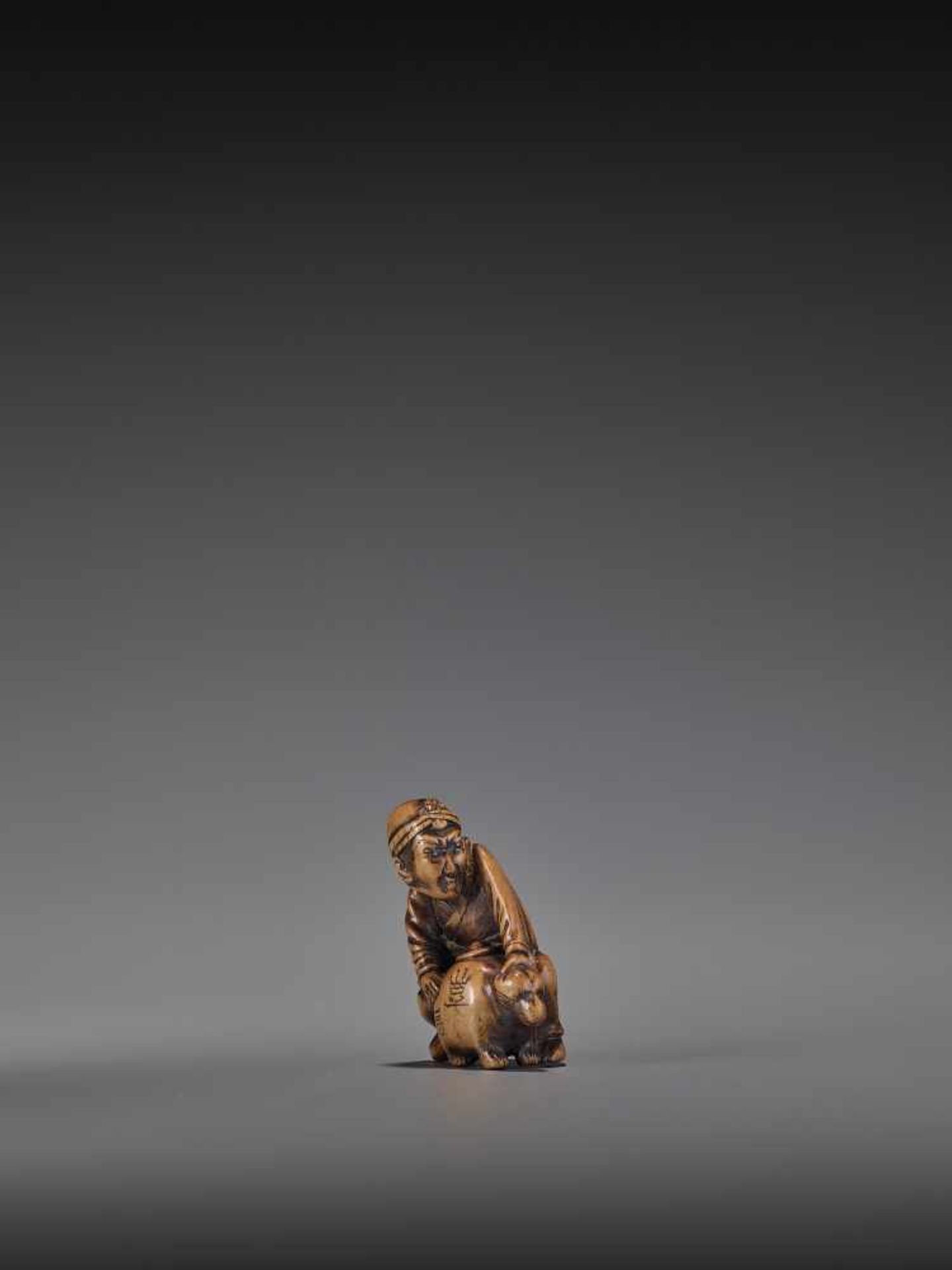 HIDEHISA: A RARE WOOD NETSUKE OF A THIEF STEALING THE MAGIC TANUKI KETTLE By Hidehisa, signed