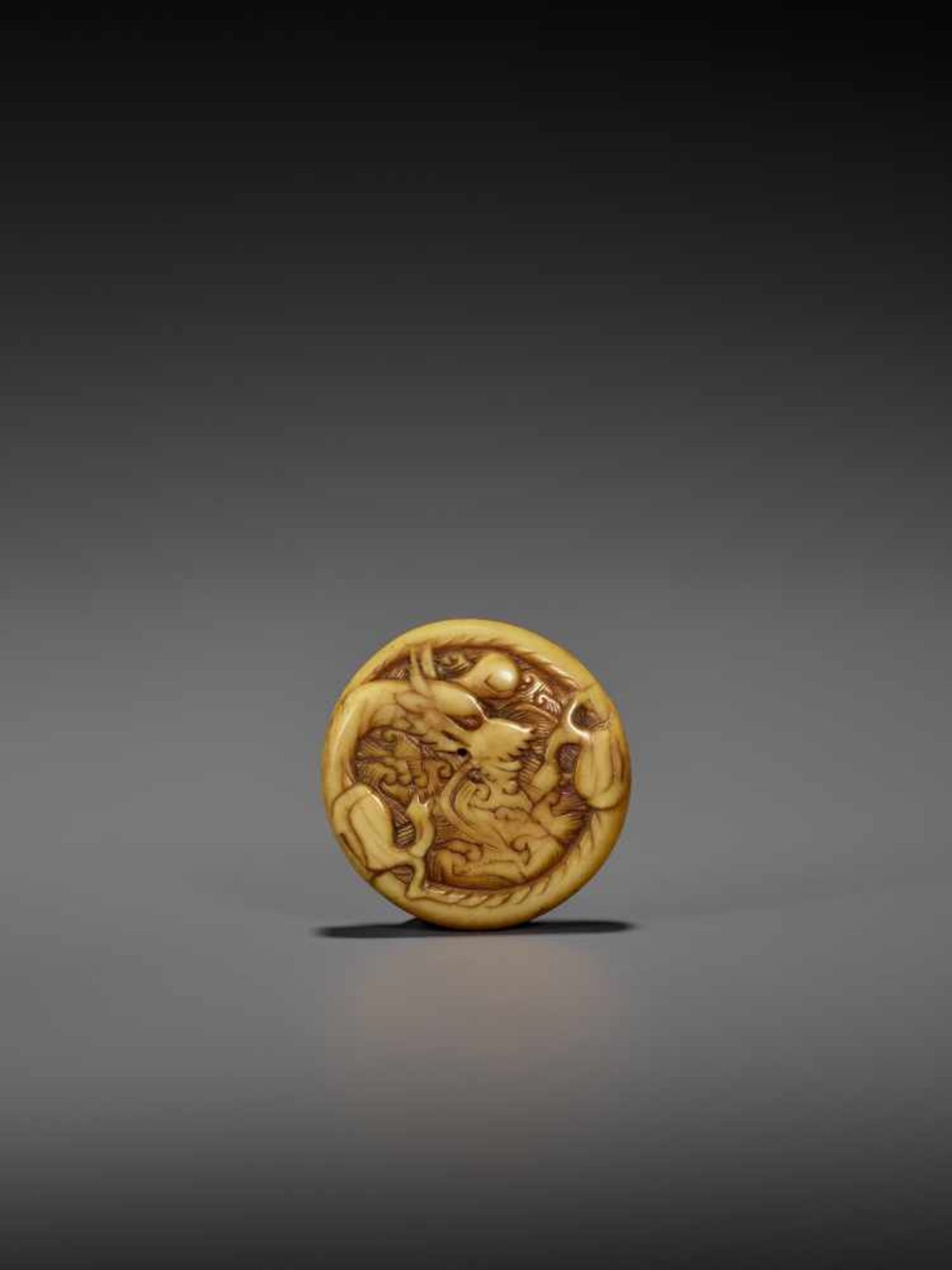 AN EARLY POWERFUL IVORY MANJU NETSUKE WITH DRAGON UnsignedJapan, early to mid-18th century, Edo