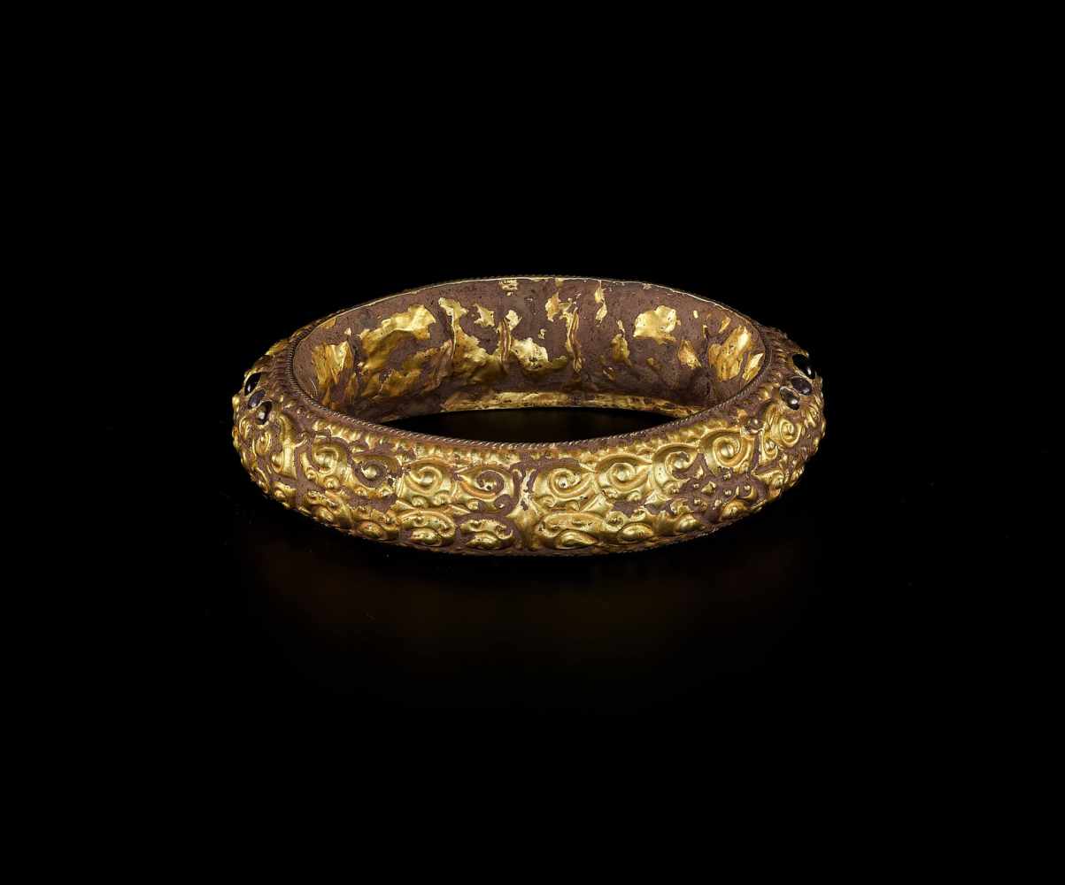 A CHAM REPOUSSÉ GOLD BRACELET WITH A GEMSTONE FLOWER AND GUARDIAN LIONS Champa, classical period, - Image 4 of 4