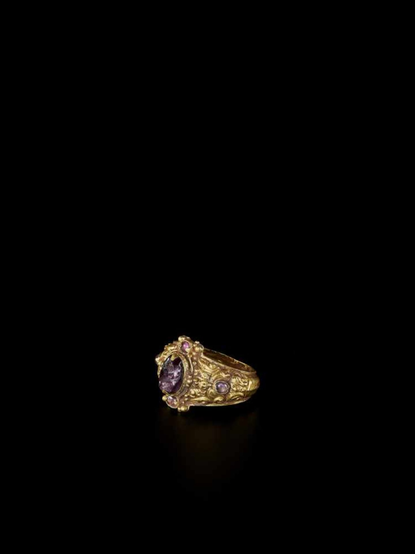 A CHAM REPOUSSÉ GOLD RING WITH AMETHYSTS Champa, c. 10th – 12th century. The richly decorated ring