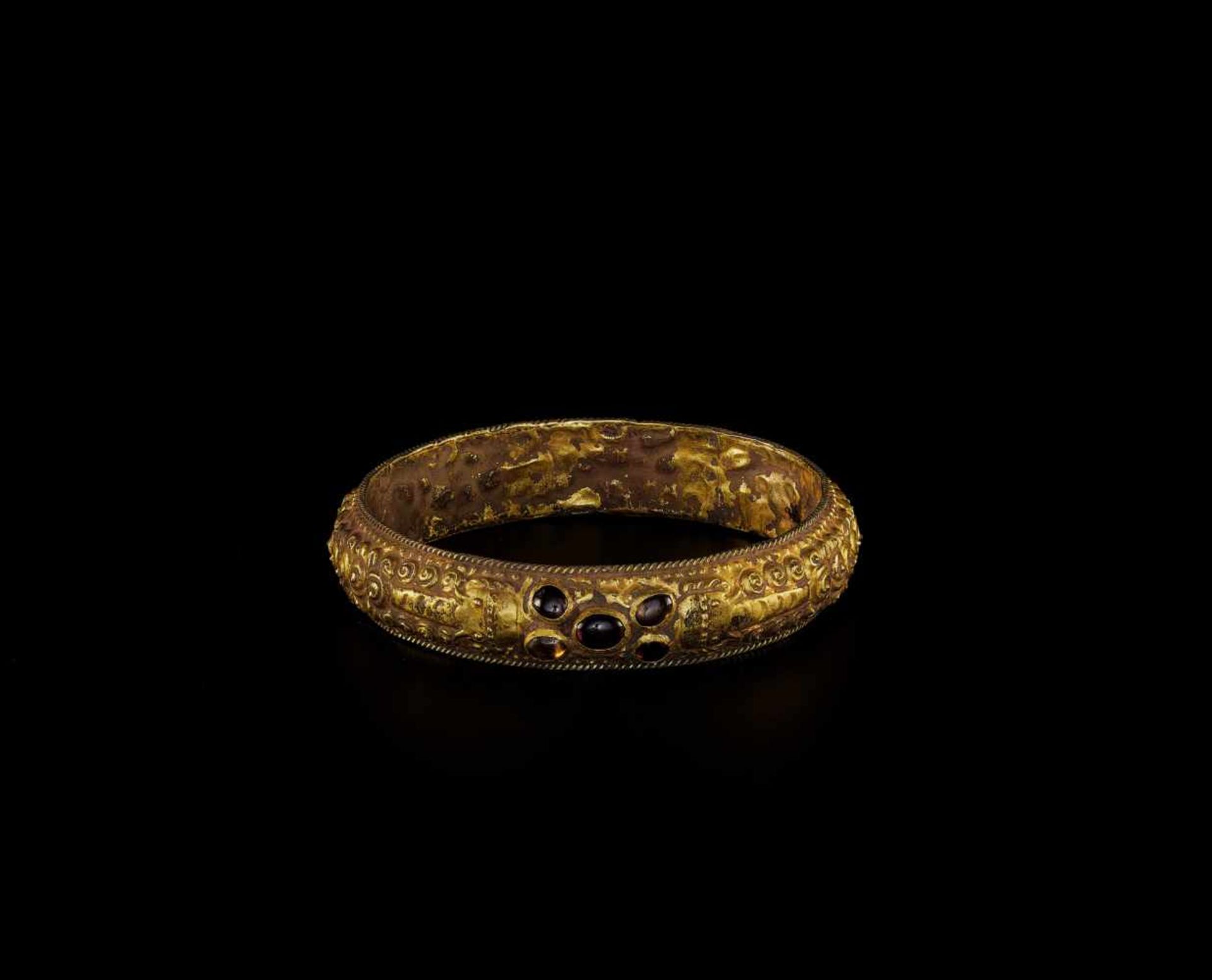 A CHAM REPOUSSÉ GOLD BRACELET WITH A GEMSTONE FLOWER AND ELEPHANTS Champa, classical period,