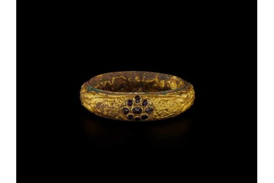 A CHAM REPOUSSÉ GOLD BRACELET WITH A GEMSTONE FLOWER AND GUARDIAN LIONS Champa, classical period, - Image 1 of 4