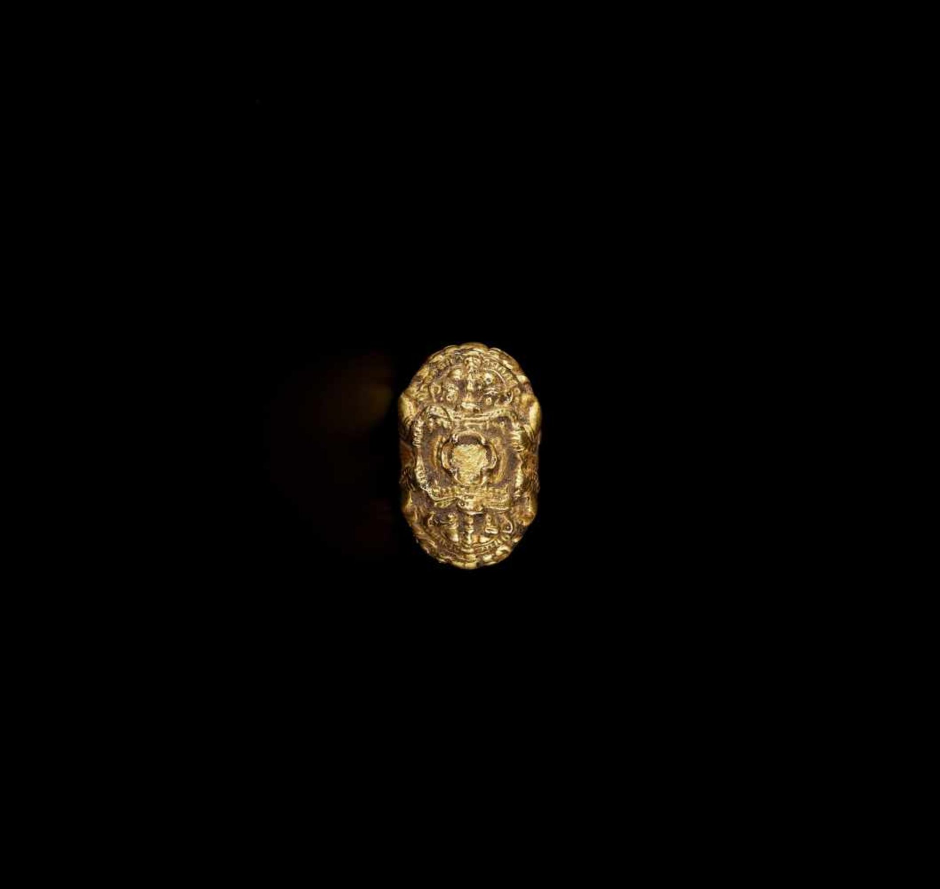 A MASSIVE GOLD RING DEPICTING KALA South Vietnam, 20th century. The top of the ring shows two