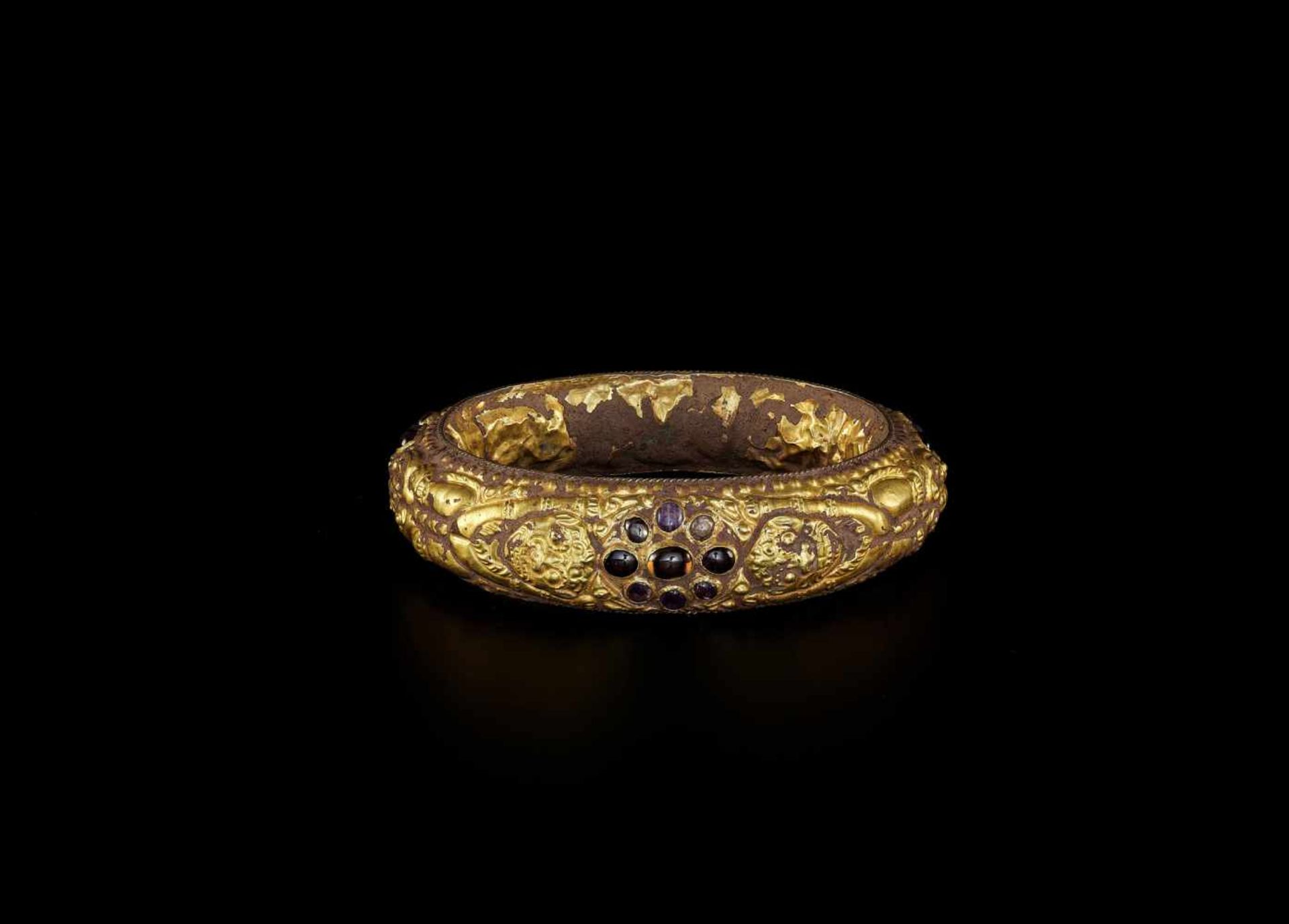 A CHAM REPOUSSÉ GOLD BRACELET WITH A GEMSTONE FLOWER AND GUARDIAN LIONS Champa, classical period,