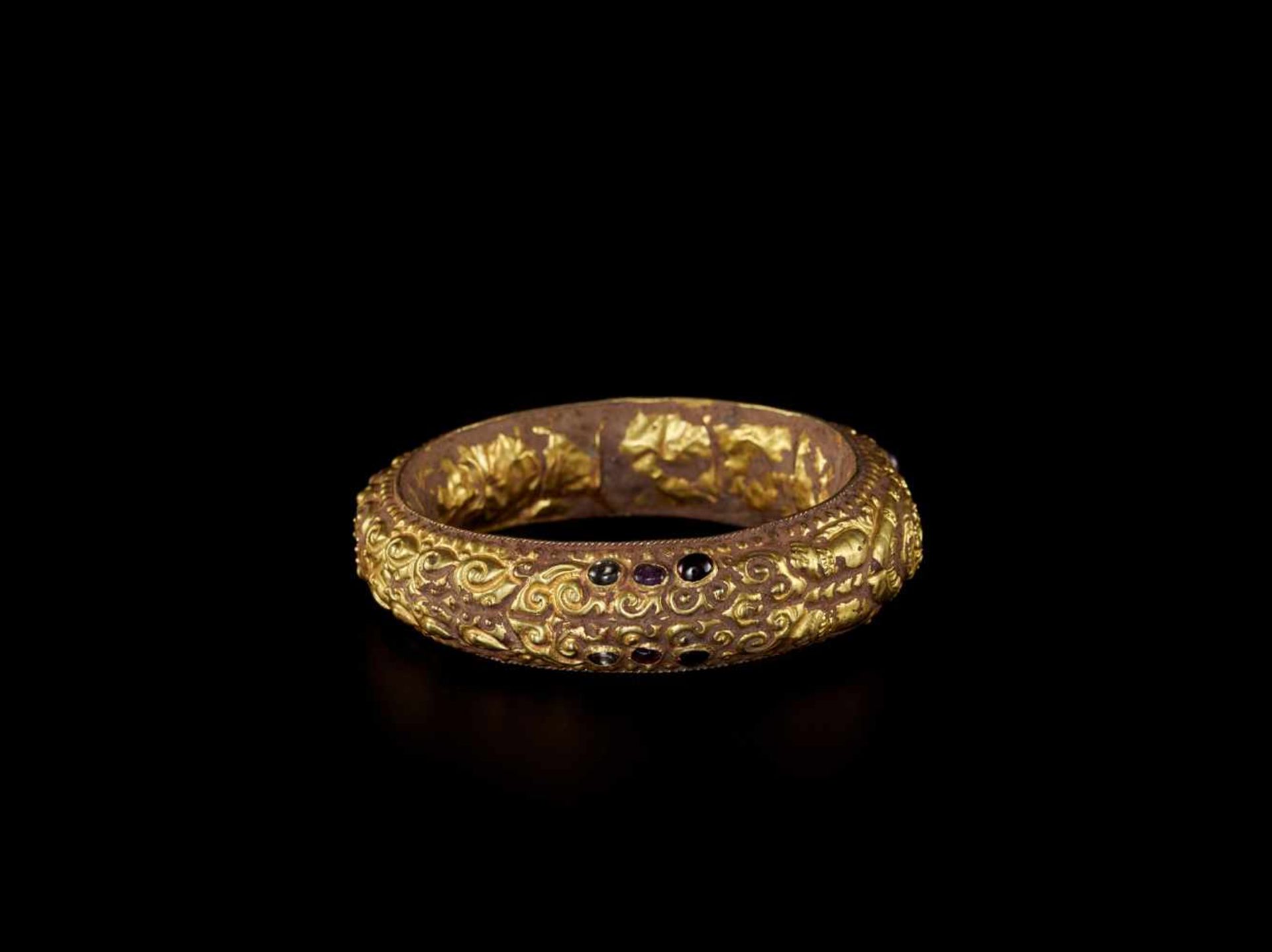 A CHAM REPOUSSÉ GOLD BRACELET WITH A GEMSTONE FLOWER AND GUARDIAN LIONS Champa, classical period, - Bild 3 aus 4