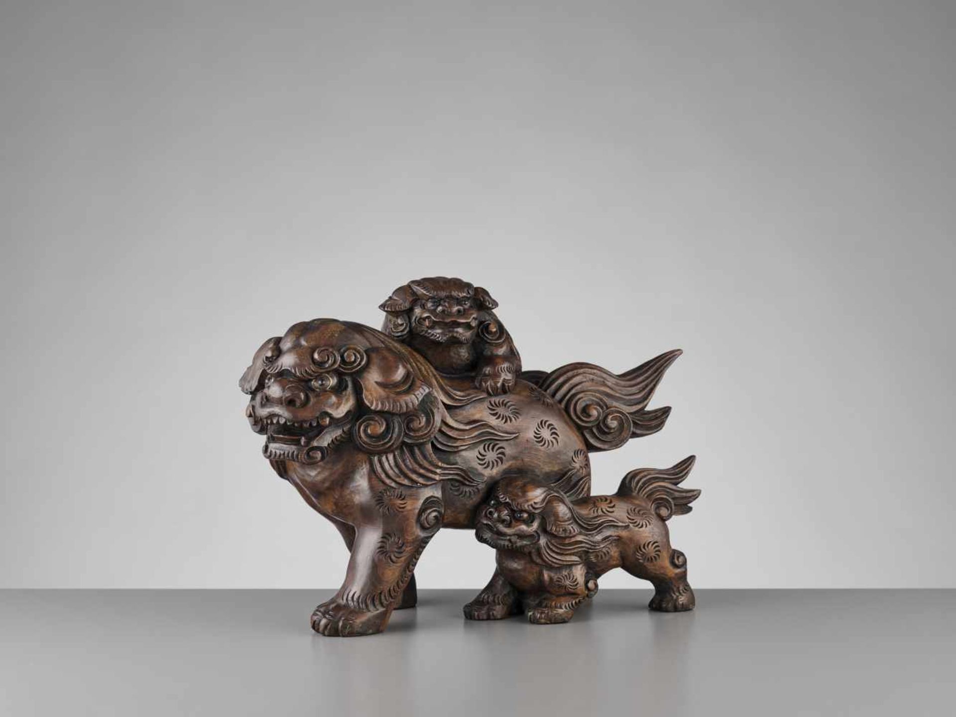 A RARE HINOKI WOOD SHISHI WITH TWO PUPS Japan, ca. 1800-1850, later Edo period (1615-1868)A simple