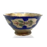 Persian bowl decorated on the outside with floral patterns within large blue lines and diamond