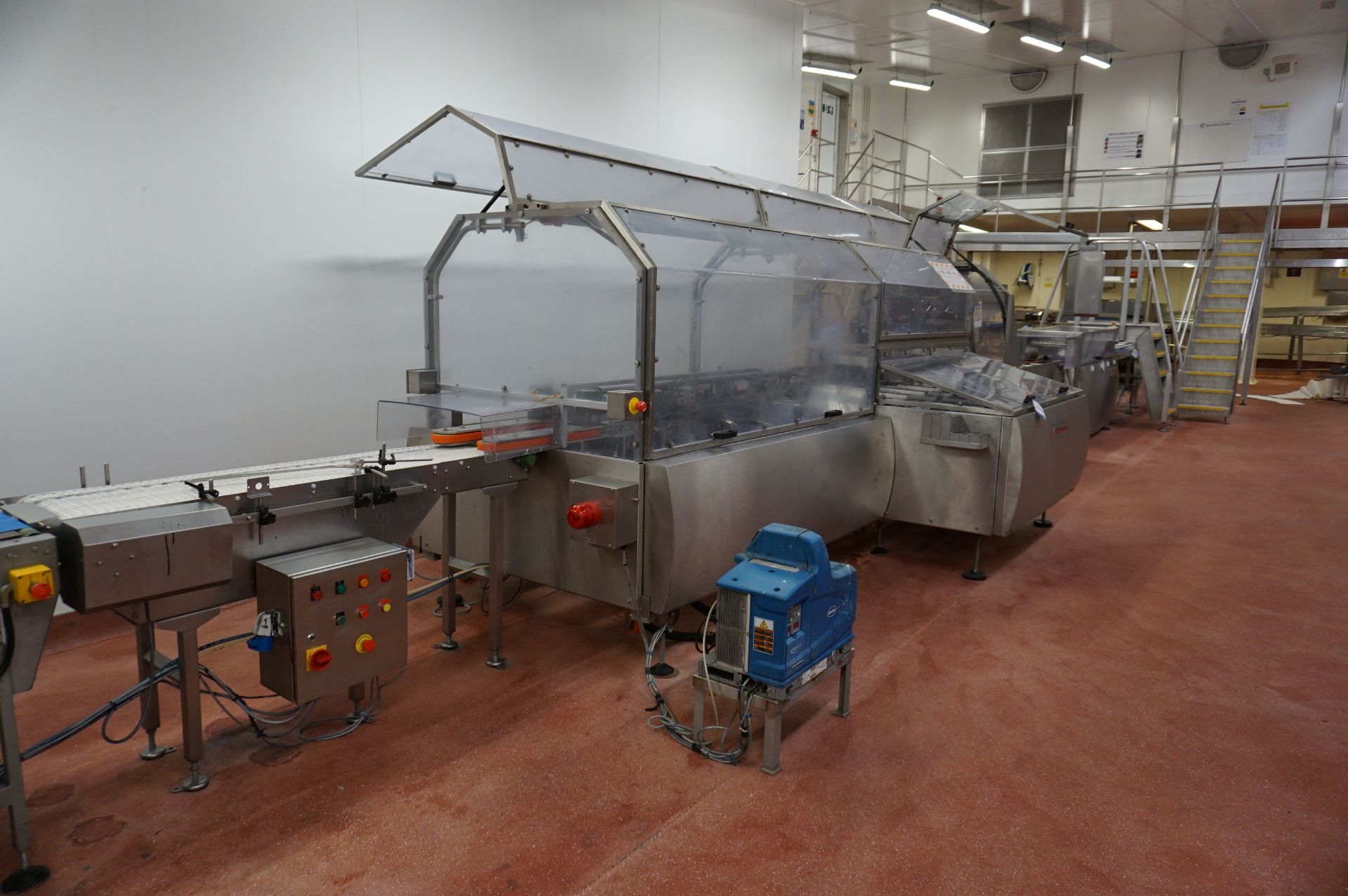 Bradman Lake Packaging Station Comprising: curved plastic slat decline conveyor to motorised