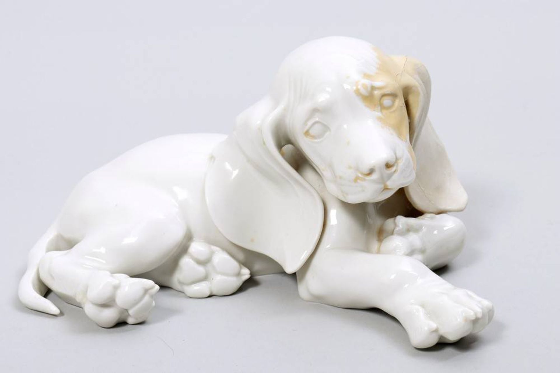 Reclining dachshund Allach, 1933-45, porcelain, pressmarks, L: ca. 18cm, 1 ear restored, discoloured