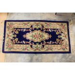 A Chinese hand knotted woollen rug, having a blue and cream ground, floral decoration, 170cm high,