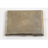 A silver cigarette case, machine engraved pattern, monogram to the front,