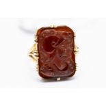 A gold and garnet cameo ring, carved with classical Roman figures, the cameo approx.