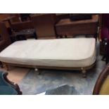 An early 20th Century giltwood cream upholstered day bed,