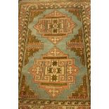 A 20th Century geometrical patterned aztec woollen rug, pale green, cream and salmon,