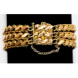 An 18ct gold (stamped) bracelet, comprising three fancy link chains and a box clasp detail,