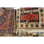 A Peruvian hand knotted woollen rug, having a geometric design, with a red and cream ground,