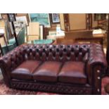 A Chesterfield burgandy leather deep buttoned upholstered settee, of recent manufacture, 65cm high,