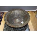 An early Islamic copper bowl, with fluted sides and engraved centre, signed to rim, 39cm diameter,