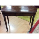 An early 19th Century mahogany fold out tea table, having reeded legs,