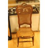 A late Victorian canework ladies chair, with canework seat and back, open carved handle,