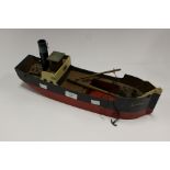 A wooden clockwork toy boat, painted in black and red,