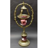 A late Victorian cranberry "floating candle lamp" hanging in ormolou frame and stand