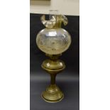 A brass twin burner oil lamp with funnel and glass globe